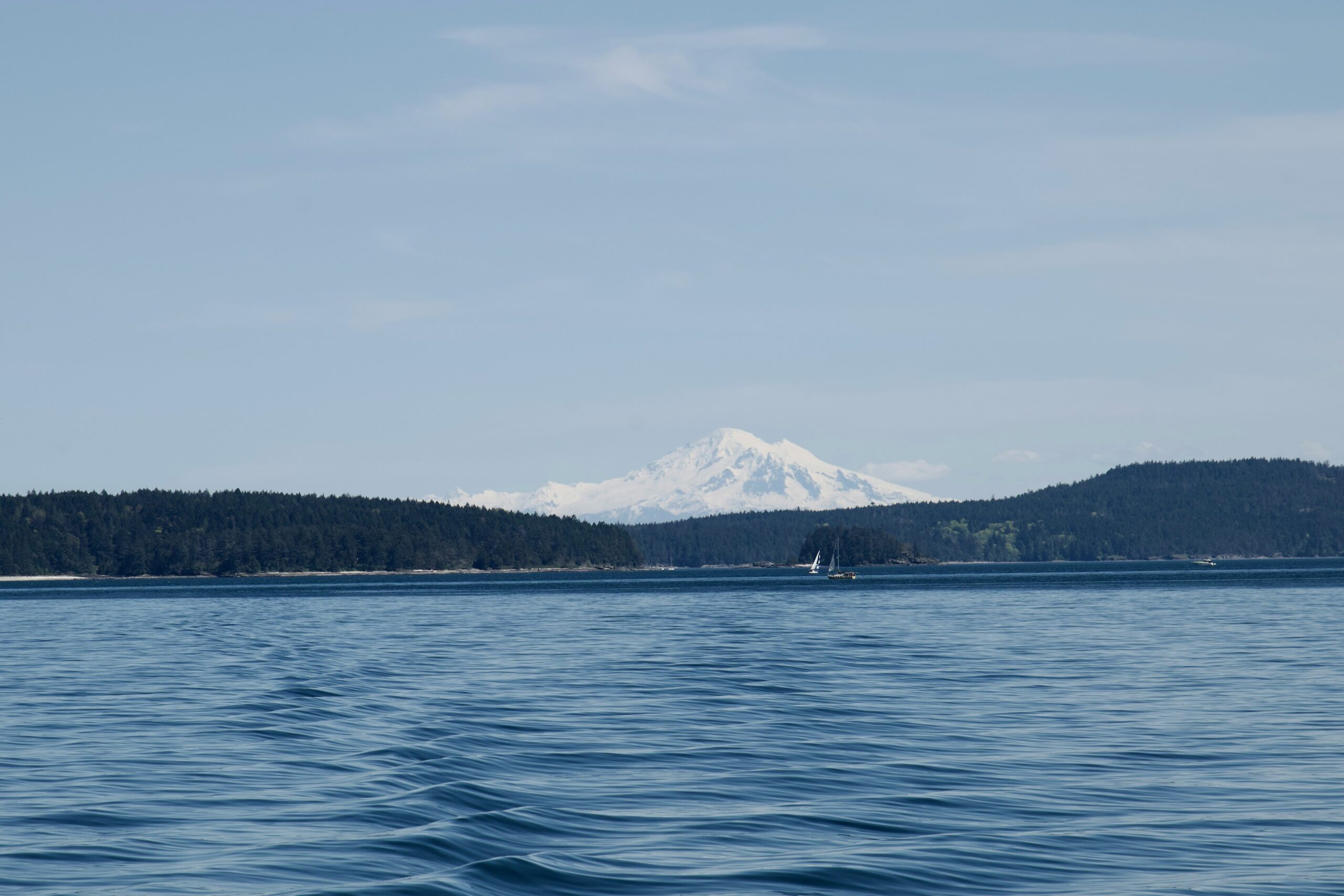 a large body of water with a mountain in the background